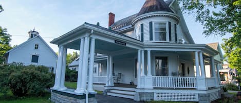 A two-story house with a wrap-around porch and a distinctive turret.