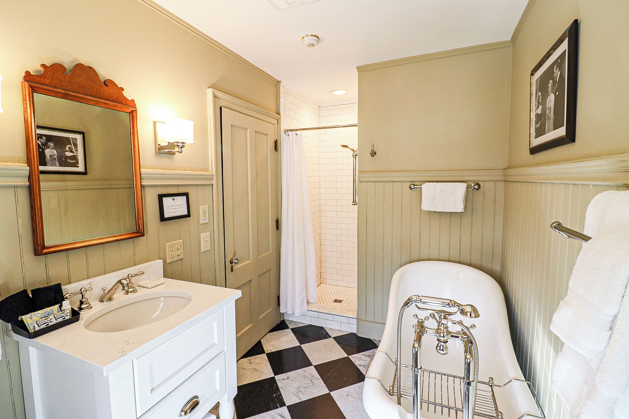 A bathroom with a checkered floor, two sinks, a bathtub, and a shower.