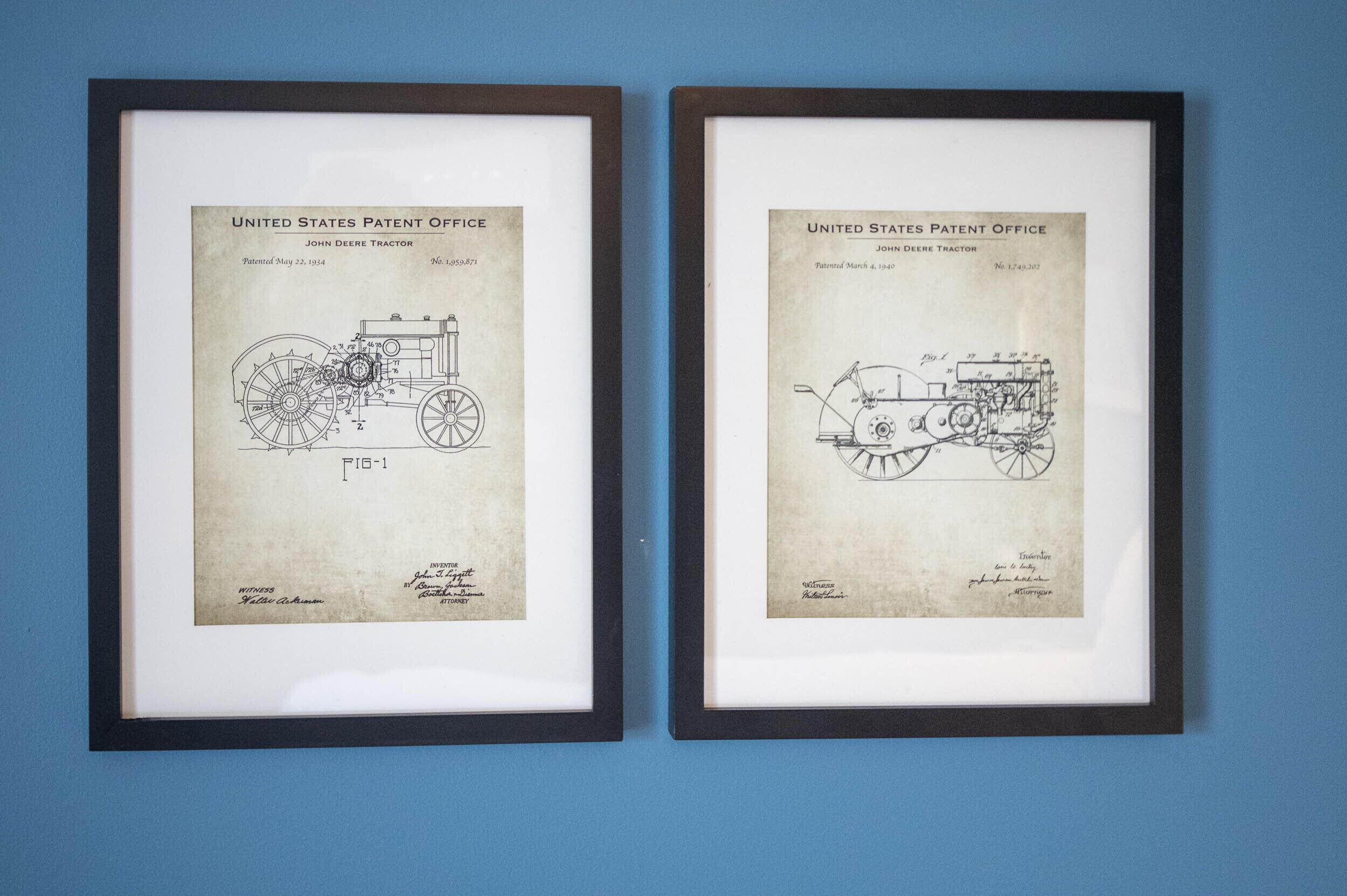 Two framed patent drawings of John Deere tractors.