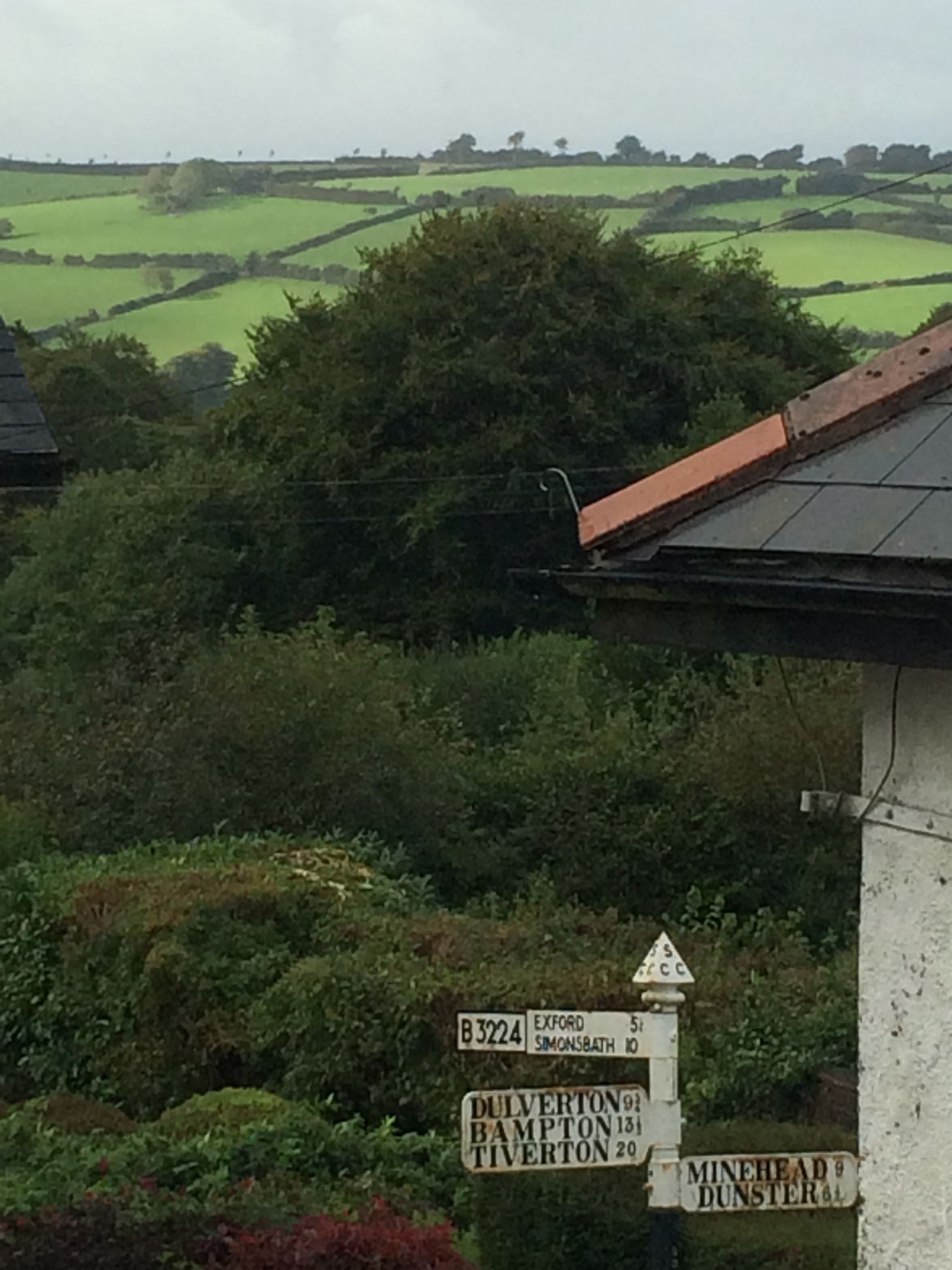 Ein ländlicher Wegweiser mit den Zielen Exeter, Simonsbath und Minehead.