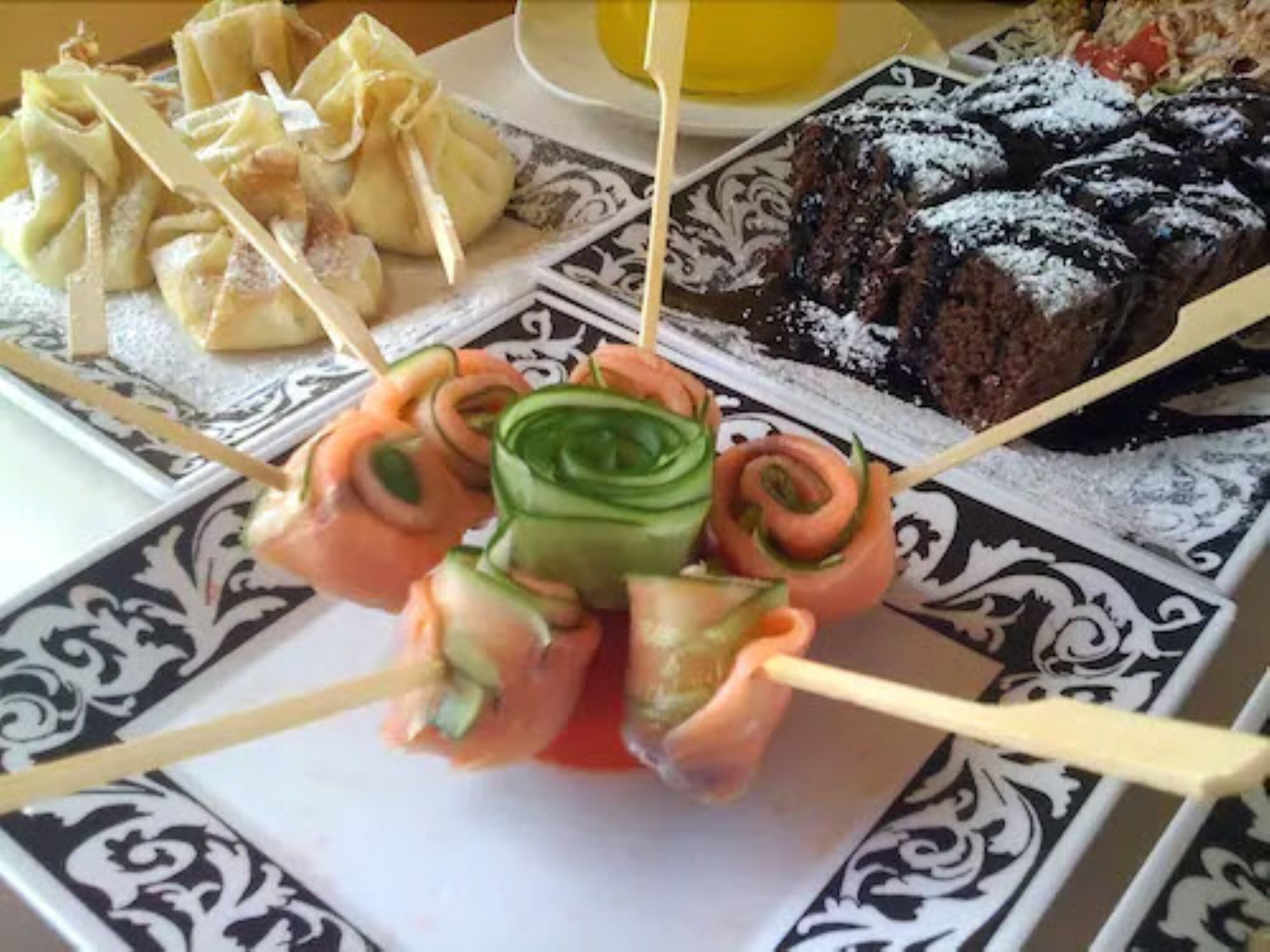 Un plato con rollos de sushi, dumplings y un postre.