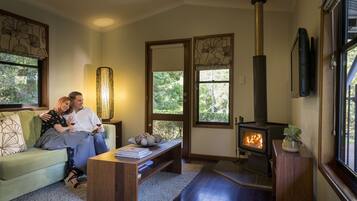 A cozy living room with a fireplace, a sofa, a coffee table, and a TV.