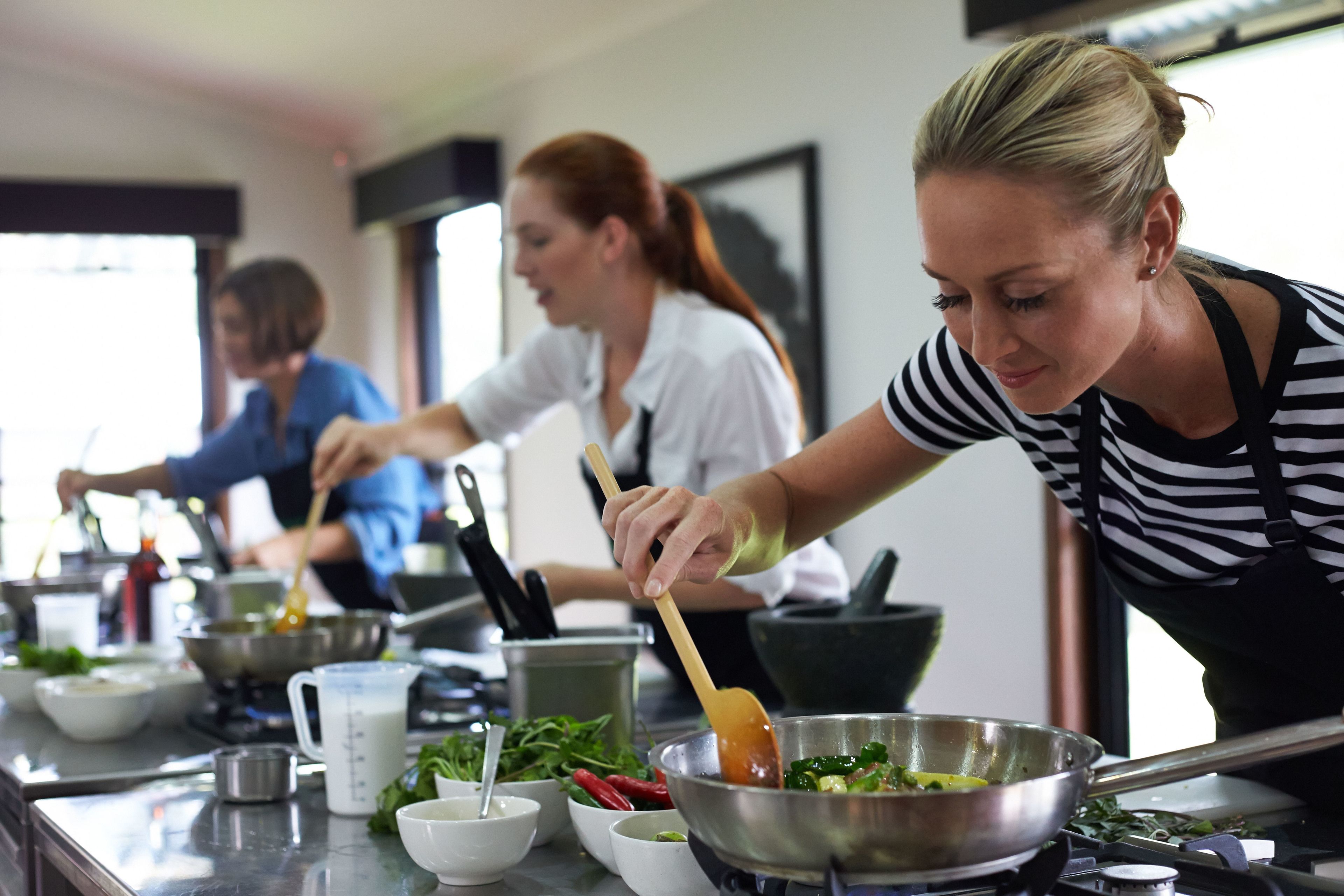 A kitchen with three chefs preparing food.