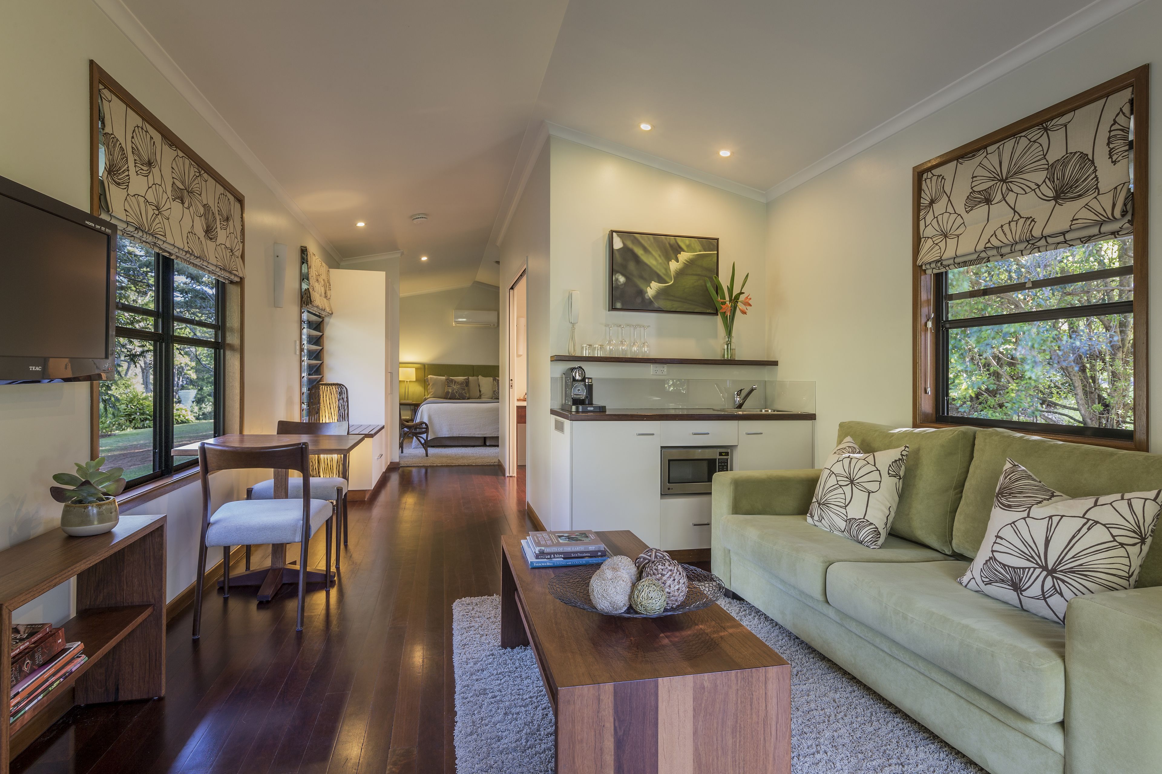 A modern living room with a sofa, coffee table, and dining area.