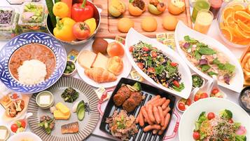 Variedad de platos con arroz, carne, verduras y frutas sobre una mesa.