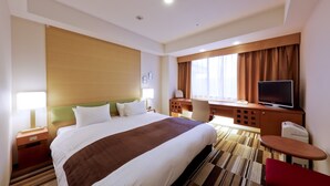 A hotel room with a large bed, a desk, a television, and a window with curtains. - Hotel the Lutheran (Osaka)