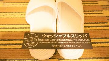 A pair of white slippers with a label that reads "WASHED SLIPPERS".