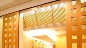 A hallway with wooden flooring and a sliding door with a grid pattern. - Hotel the Lutheran (Osaka)