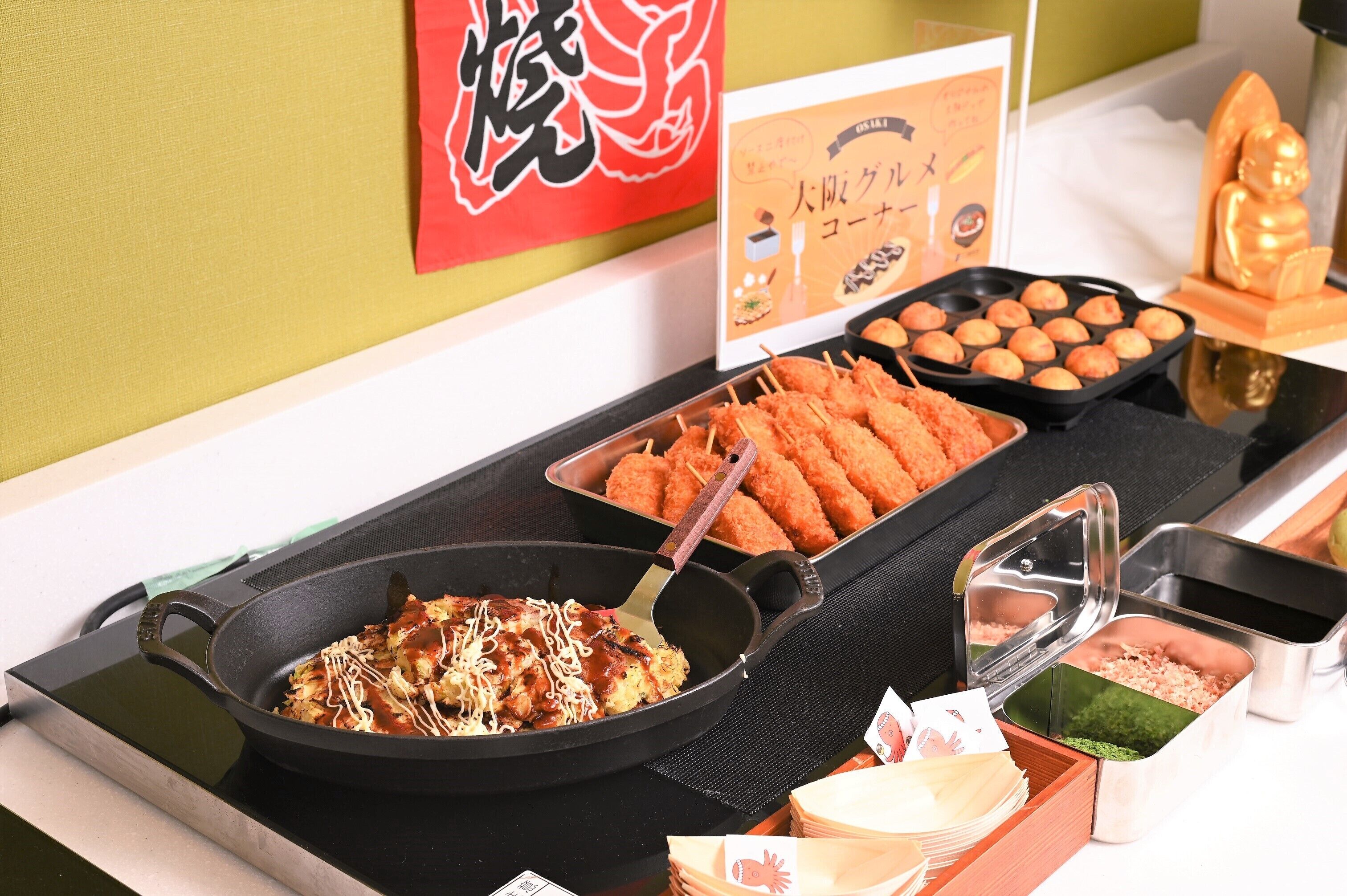 A buffet table with various dishes, including fried items and a pan with a sauce-covered dish.