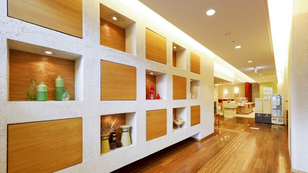 A hotel lobby with wooden panel shelving, a reception desk, and a seating area. - Hotel the Lutheran (Osaka)