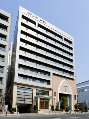 A multi-story hotel with a modern architectural design, featuring a prominent entrance with a cross above the door, indicating a religious affiliation. - Hotel the Lutheran (Osaka)