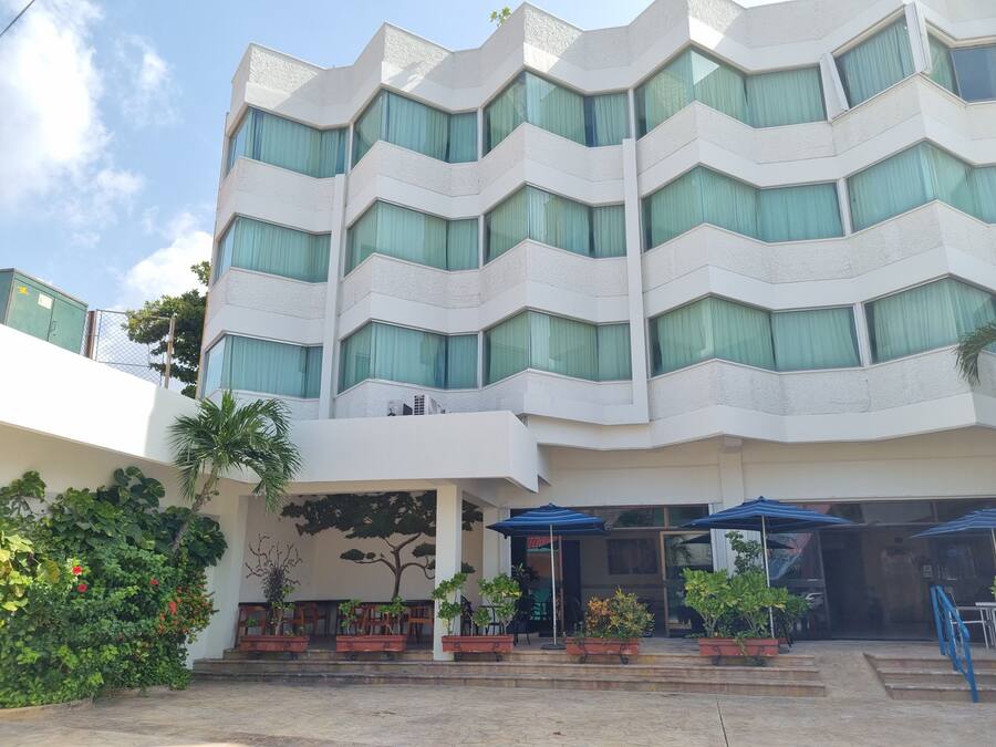 Un hôtel à plusieurs étages au design moderne, doté de nombreux balcons et de grandes fenêtres.