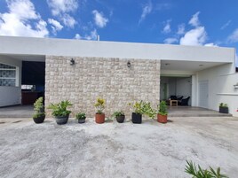Un edificio moderno con fachada de piedra y plantas en macetas al frente.