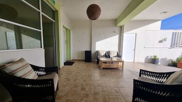 Un amplio balcón con un sofá, sillas y una mesa de centro.