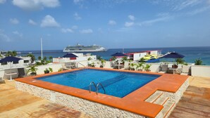 A rooftop pool with a view of the ocean and a cruise ship. - Hotel Plaza Cozumel (Cozumel)