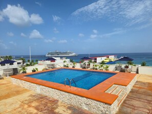 A rooftop pool with a view of the ocean and a cruise ship. - Hotel Plaza Cozumel (Cozumel)