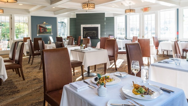 A restaurant with tables set for dining, chairs, and a fireplace in the background. - The Reluctant Panther Inn and Restaurant (Manchester)