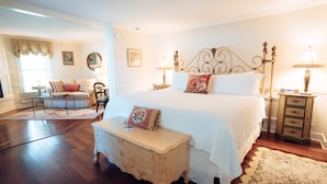 A bedroom with a large bed, bedside tables, a small bench, and a sofa in the corner. - The Reluctant Panther Inn and Restaurant (Manchester)