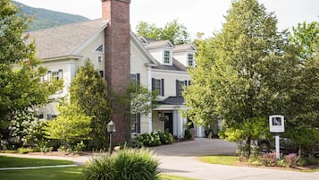 Charming two-story home with a brick chimney and a front entrance.