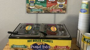 A display of Peanut Patch hot boiled peanuts in original and cajun flavors, with a price tag of $3.79 and $2.29. - Econo Lodge Conway Central (Conway)