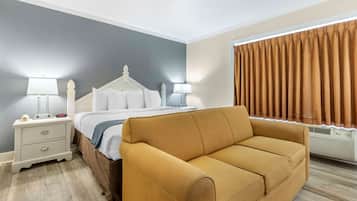 Relax in this serene space with a comfortable bed, sofa, and convenient nightstand.