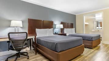 Een hotelkamer met twee bedden, een bureau, een stoel en een spiegel.