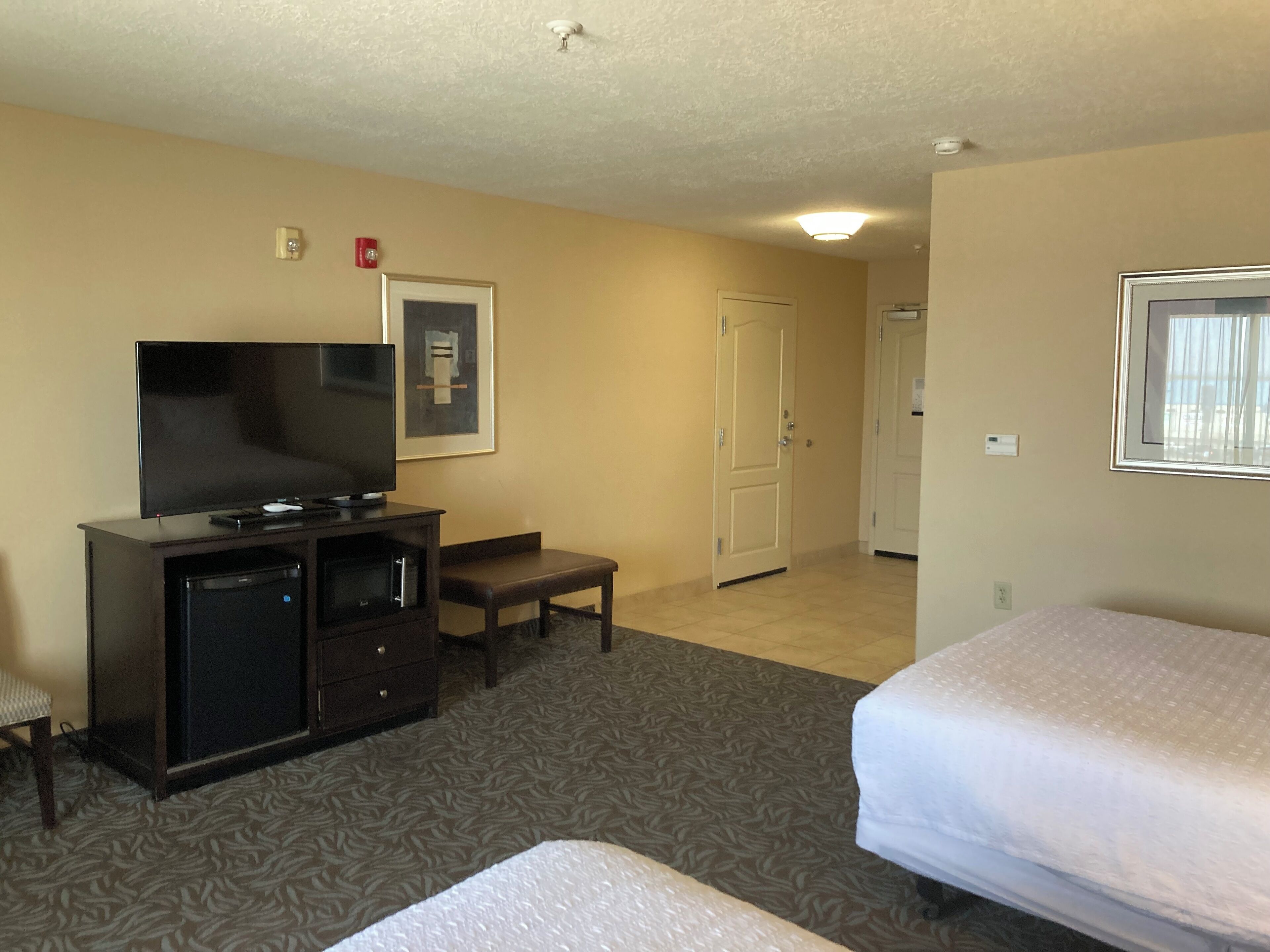 A hotel room with a bed, a TV, a desk, and a chair.