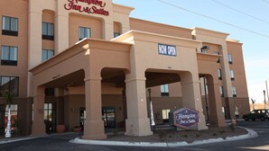 A Hampton Inn & Suites building with a 'NOW OPEN' sign, multiple entry points, and a clear sky. - Hampton Inn & Suites Carlsbad (Carlsbad)
