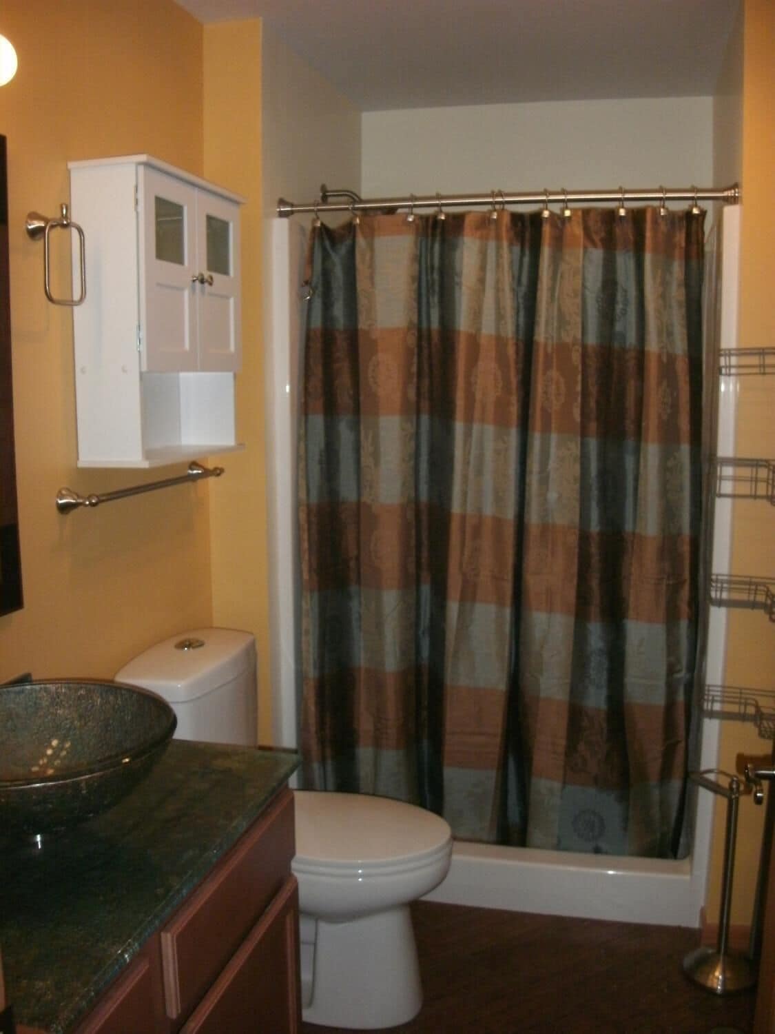 Un baño con inodoro, lavamanos, cortina de ducha y toallero.