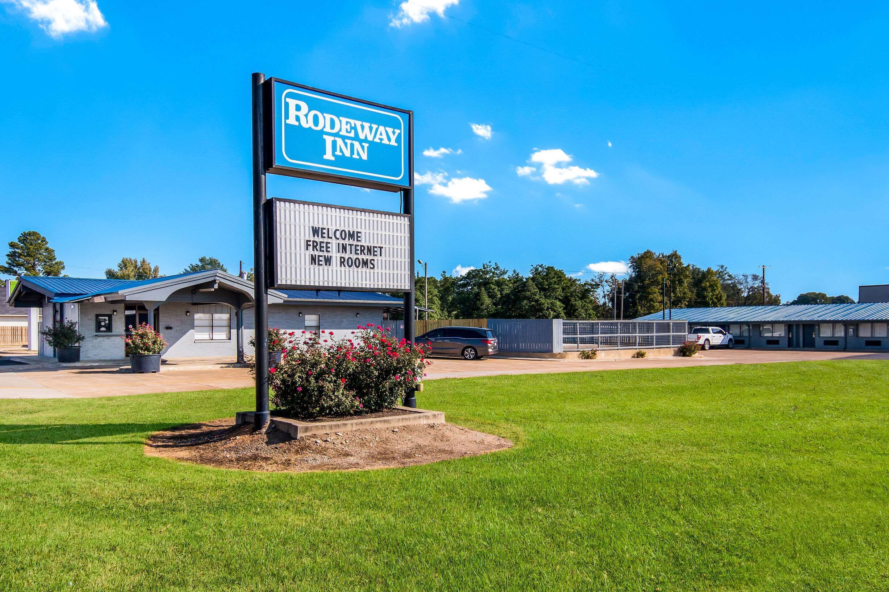 Placa da Rodeway Inn com mensagem de boas-vindas e informação sobre internet gratuita e quartos novos.