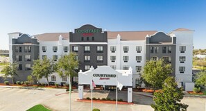 Experience the sleek, modern design of this hotel, featuring a prominent entrance and beautifully landscaped surroundings.