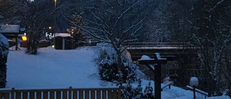 A snowy mountain landscape with a wooden fence in the foreground.
