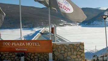 A sign for TCC Plaza Hotel in Mavrovo, with a mountainous backdrop.