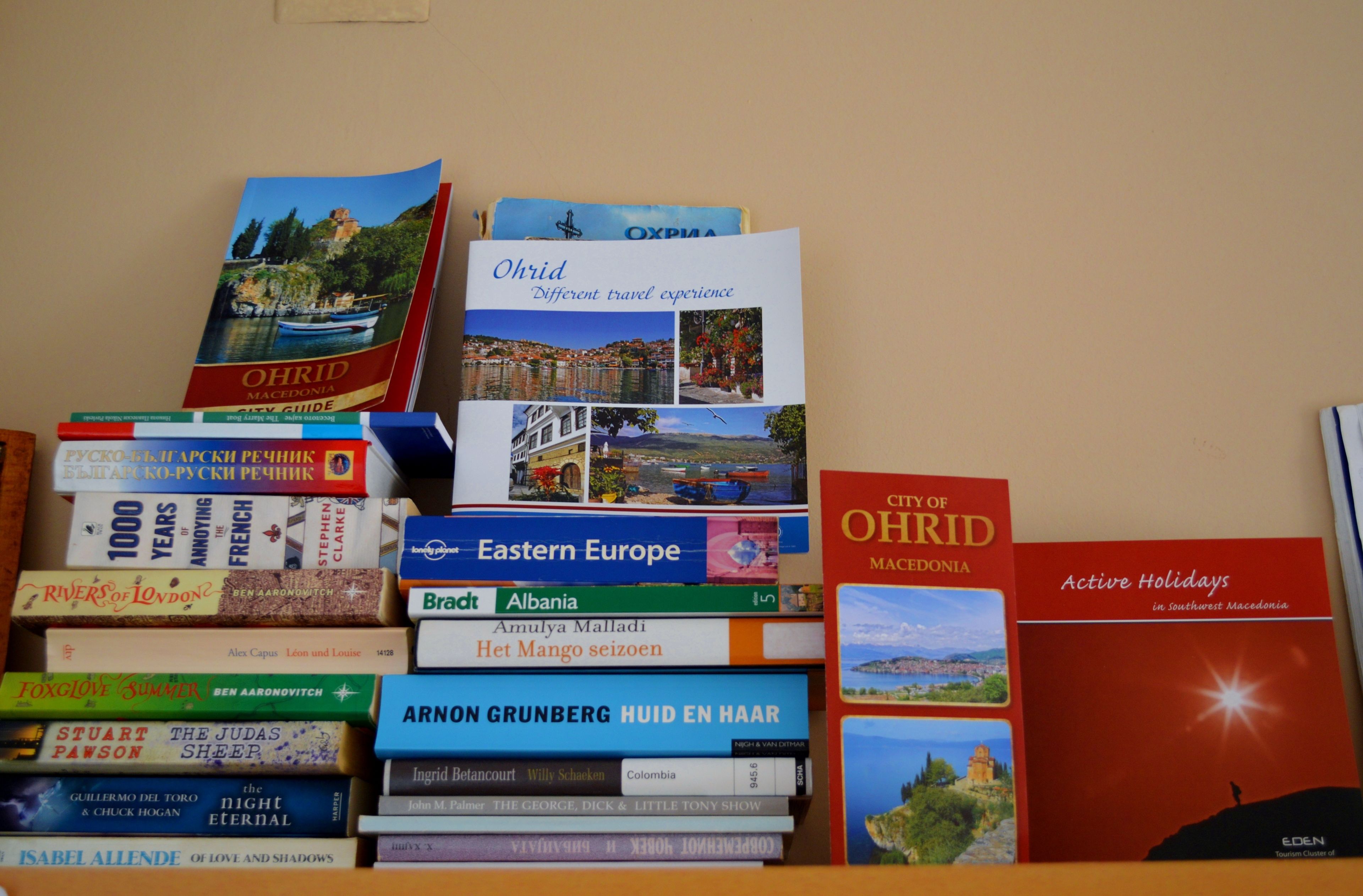 Une collection de guides de voyage sur une étagère.