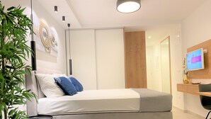 A modern bedroom with a bed, a desk, a TV, and a plant. - Villa Fani - Apartments and Rooms (Trogir)