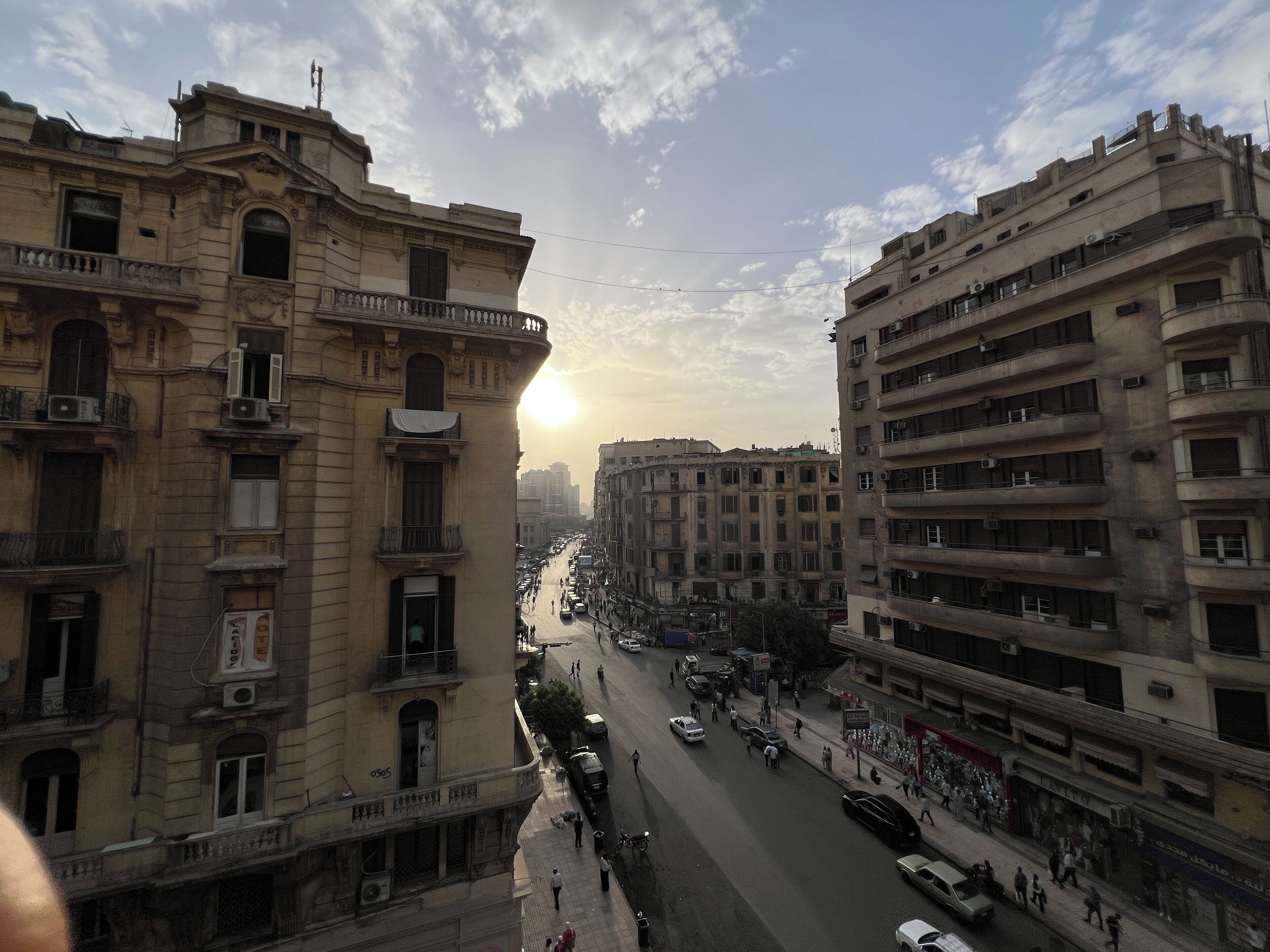 A street view with buildings, vehicles, and pedestrians.