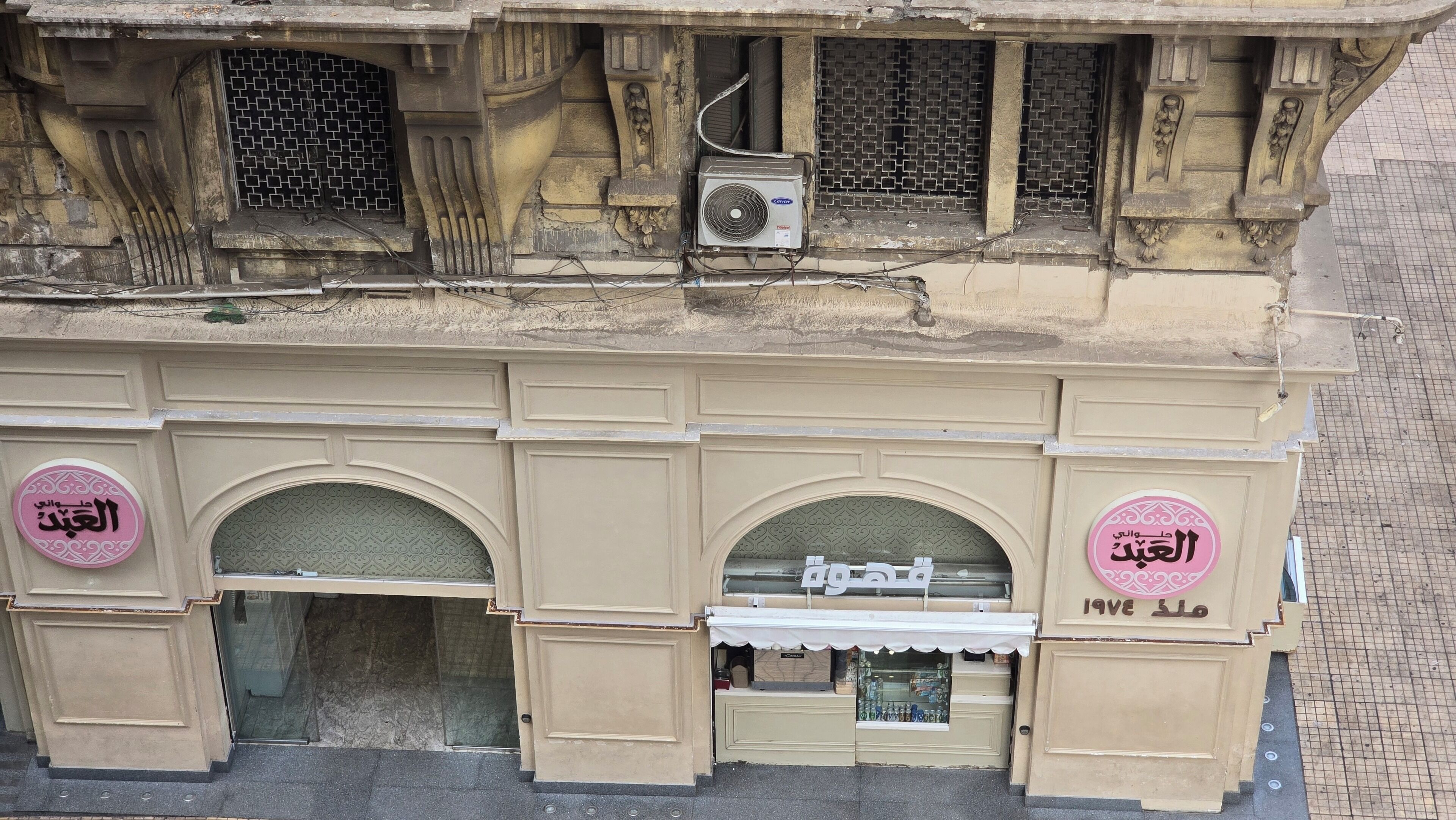A building facade with arched windows, decorative moldings, and signage.