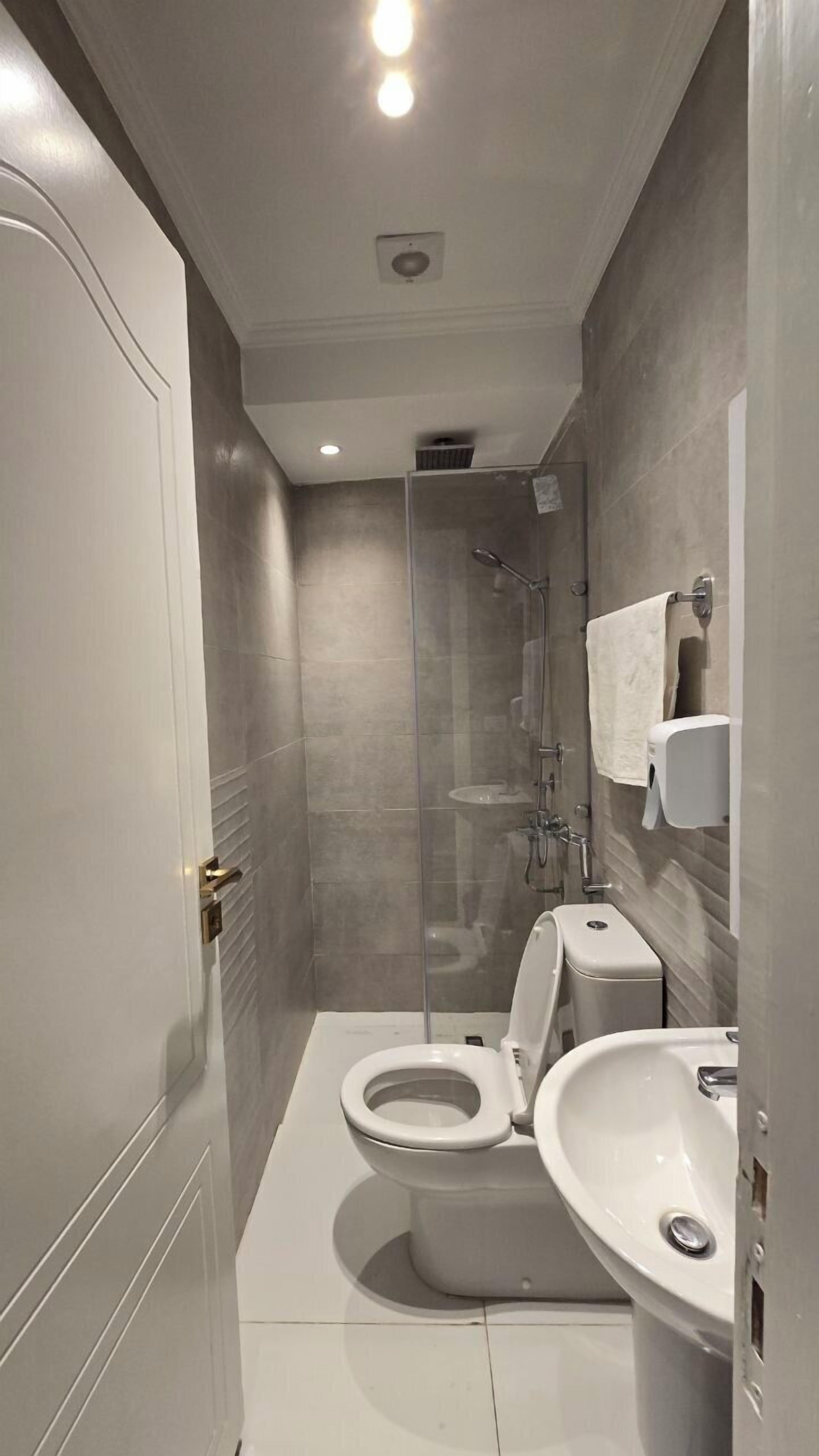 Ein modernes Badezimmer mit Toilette, Waschbecken und Dusche.