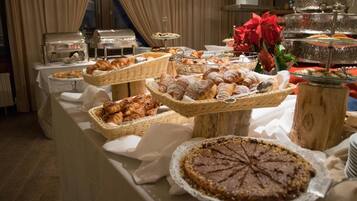 Un tavolo con vario assortimento di prodotti da forno e una torta.