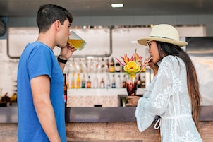 A bar area with a counter and shelves of bottles.