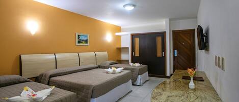 A hotel room with three beds, a marble countertop, a painting on the wall, and a TV mounted on the wall.