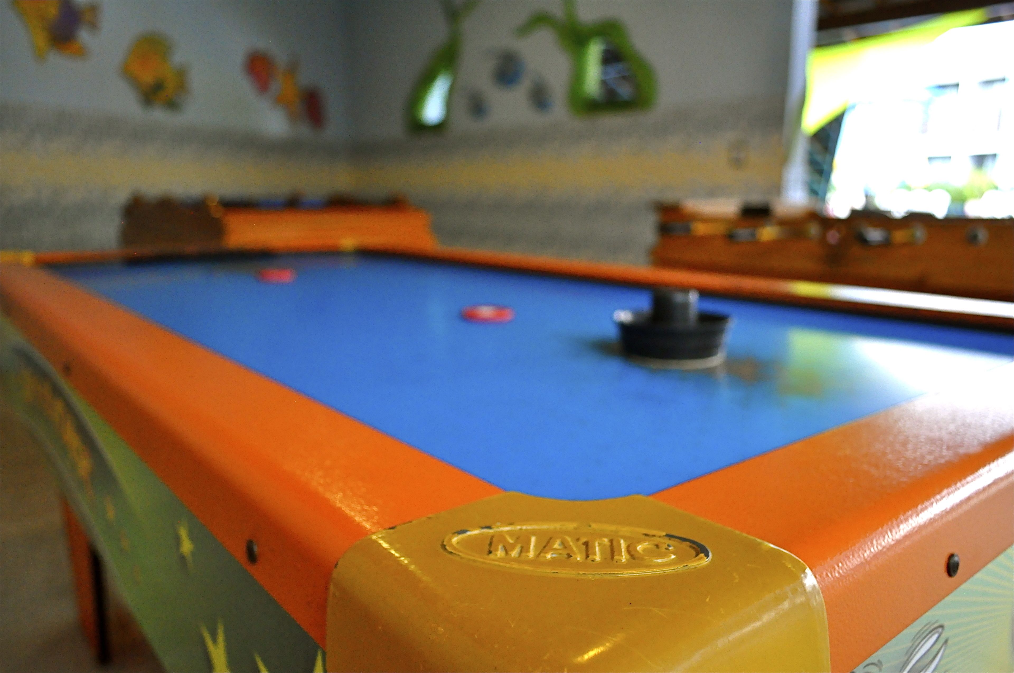 A pool table with a blue playing surface and orange borders.