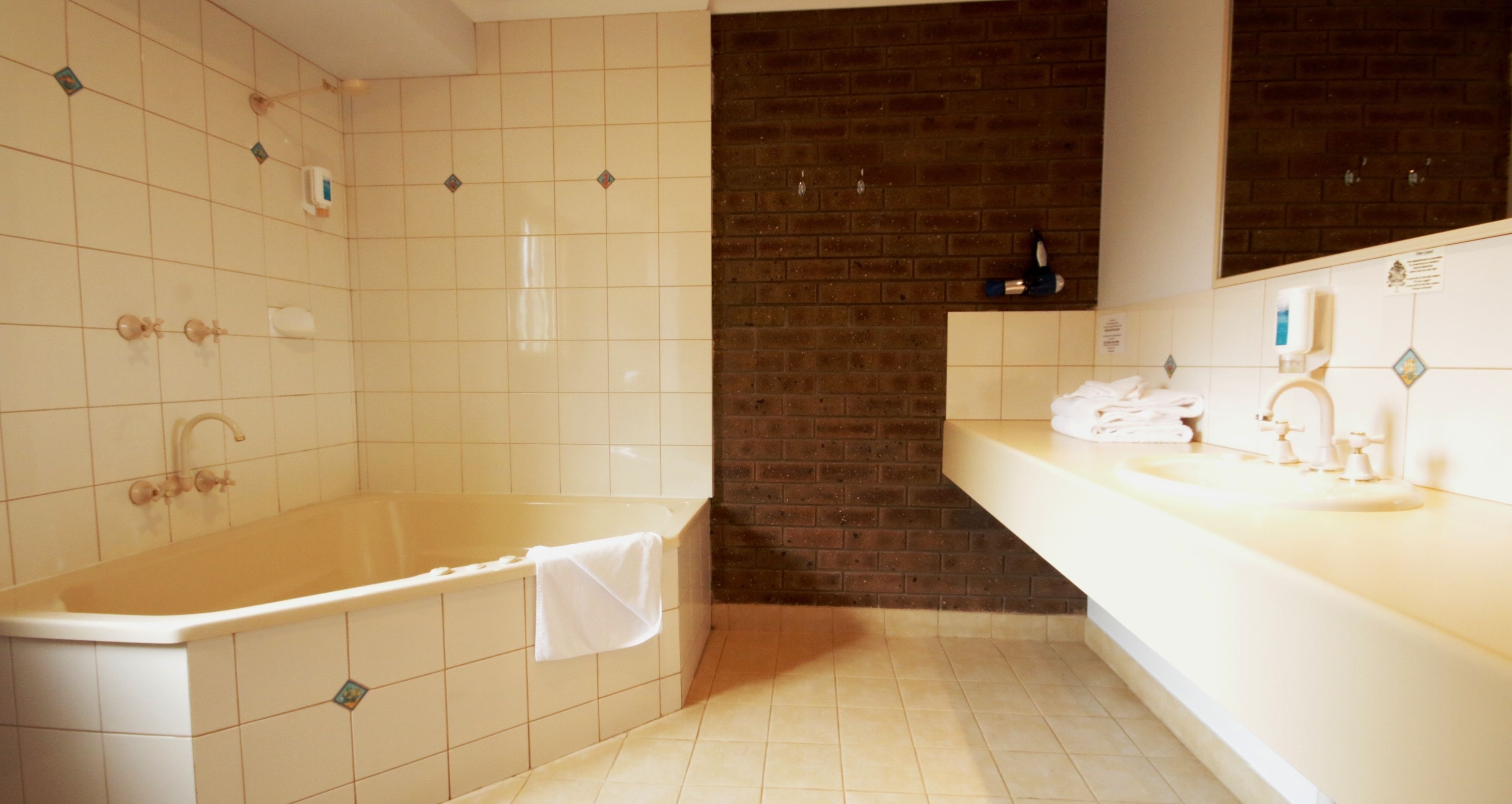 A bathroom with a bathtub, a sink, and a mirror.