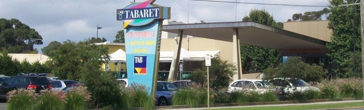 A gas station named 'TABARET' with a canopy and multiple fuel pumps.
