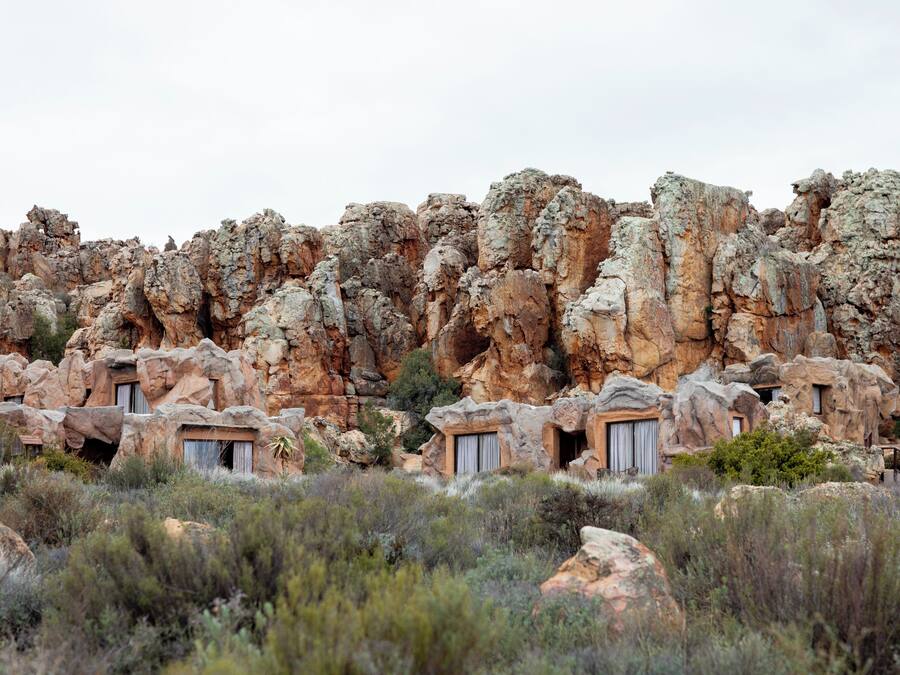 A natural rock formation with built-in structures resembling caves, possibly for accommodation.