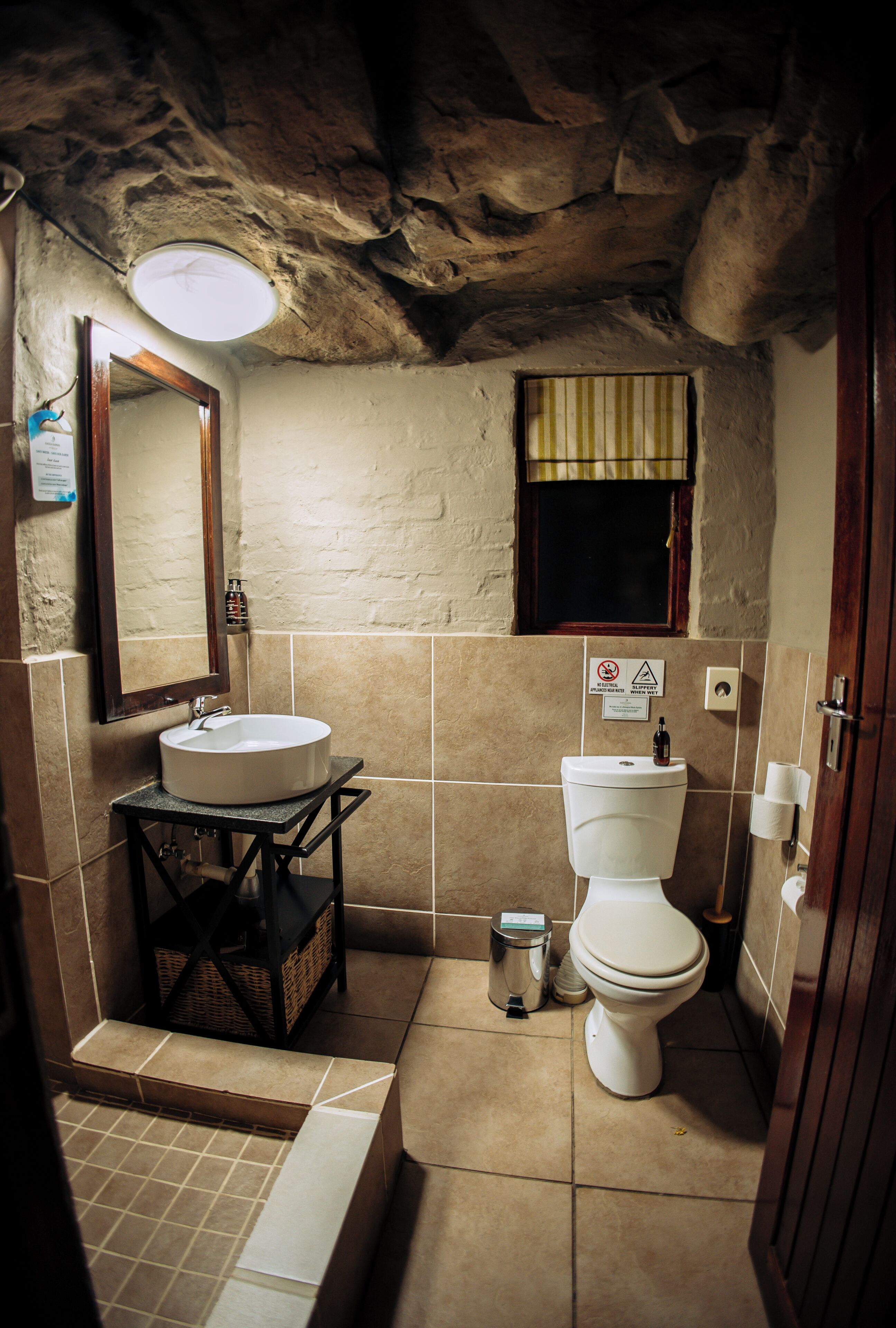 A bathroom with a sink, toilet, and a mirror.