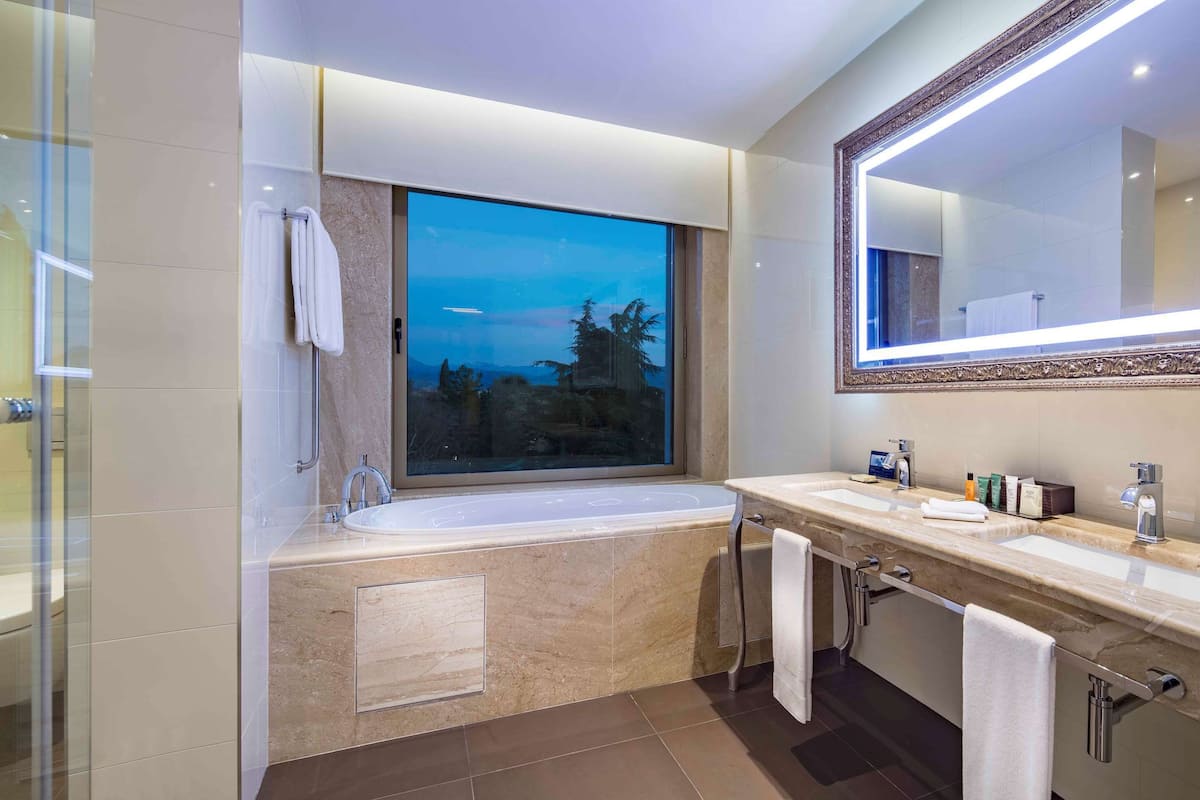 deluxe room, 1 king bed, park view | bathroom | hair dryer, slippers, towels