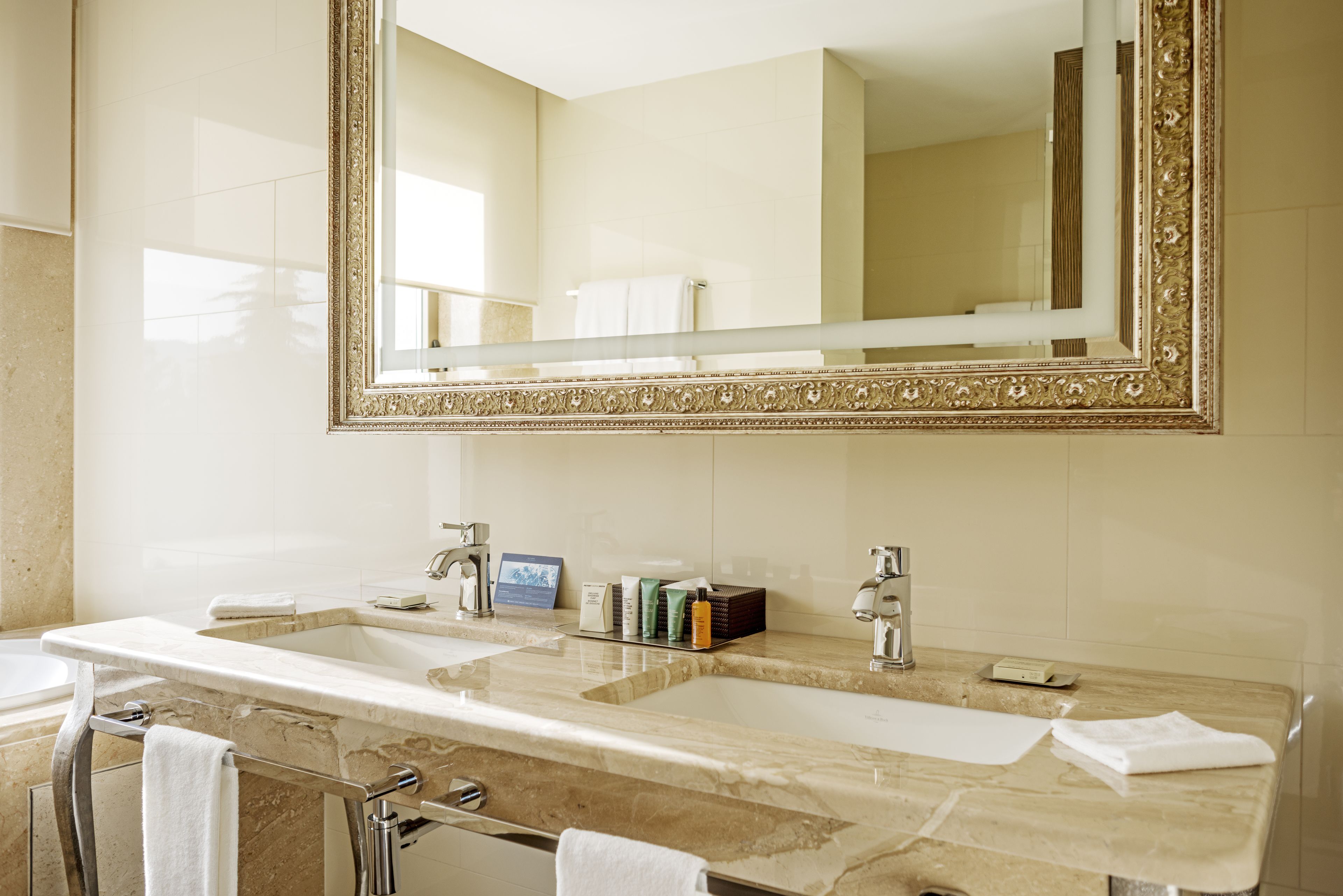 A bathroom with two sinks, a large mirror, and a towel rack.