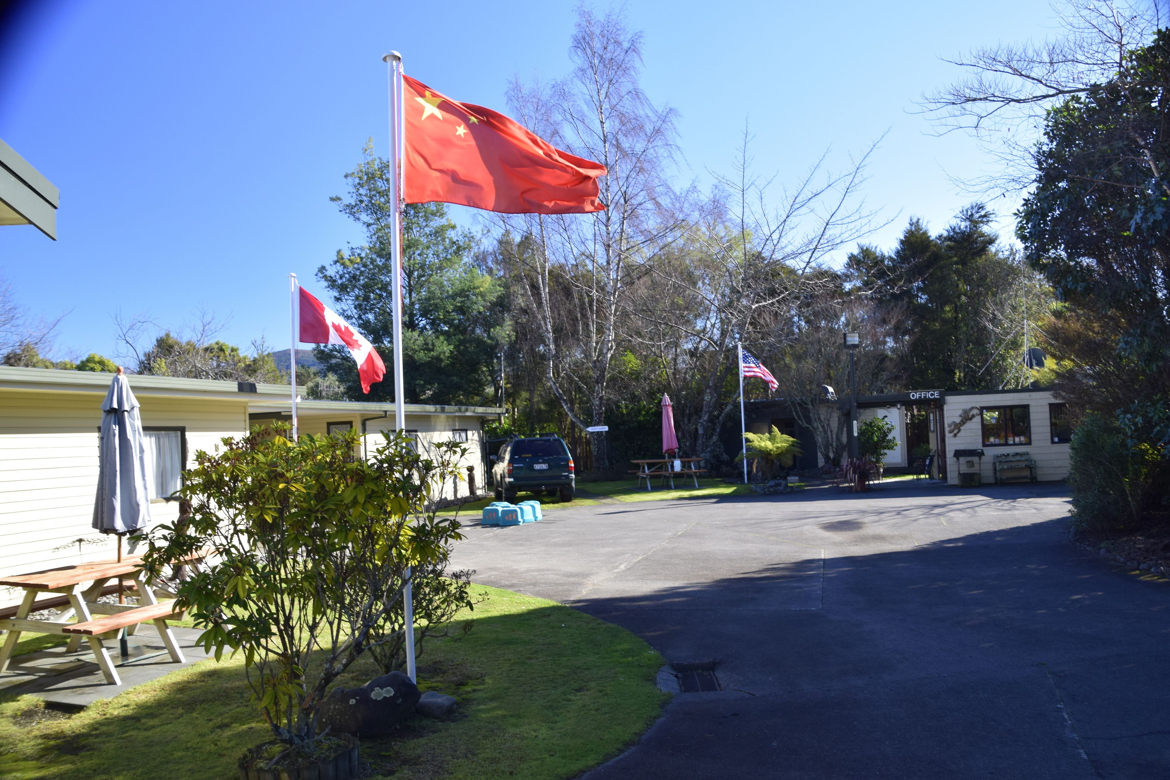 A parking area with a flagpole, picnic table, and a small building labeled "OFFICE".