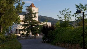 A building with a tower and a paved driveway leading to it, surrounded by trees and greenery. - Villa Turística de Laujar de Andarax (Laujar de Andarax)